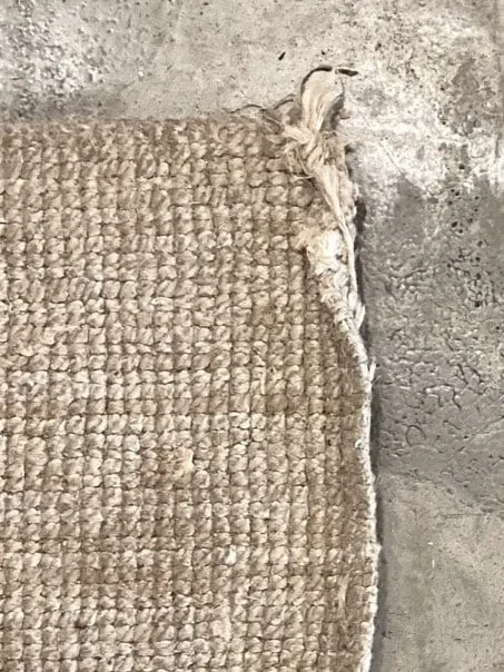 a sisal carpet on a old concrete floor, all in natural colours